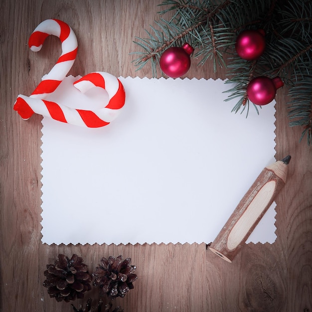 Foto leere weihnachtskarte tannenzapfen und bleistift auf hölzernem backgroun