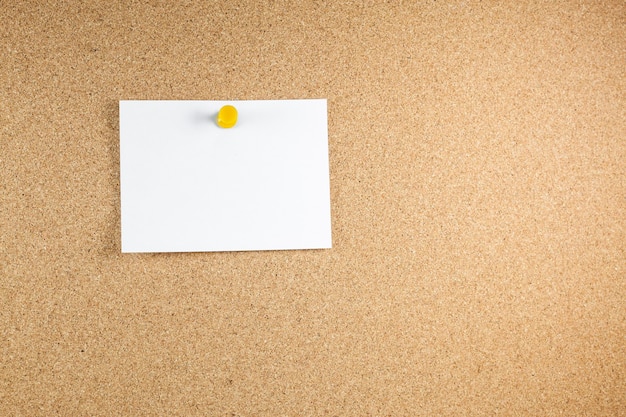Leere weiße Briefpapiere werden an eine Korkplatte geheftet.