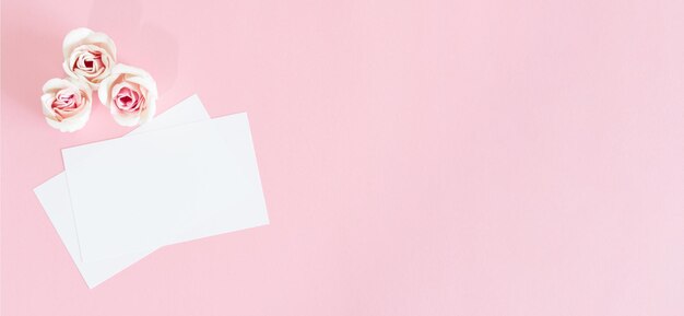 Leere weiße Grußkarte mit rosa Rosenblüten Mock-up