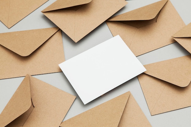 Leere weiße Karte mit Umschlagschablonenspott des Kraftpapiers braunem Papier oben