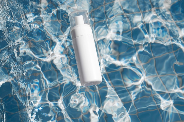 Leere weiße Kosmetik-Sonnencreme-Röhrchen-Attrappe im Schwimmbad-Körperhautpflegekonzept