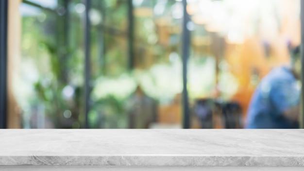 Leere weiße Marmor-Stein-Tischplatte und unscharfes Glasfenster-Innenraum-Café und Restaurant-Banner verspotten abstrakten Hintergrund - kann für die Anzeige oder Montage Ihrer Produkte verwendet werden.
