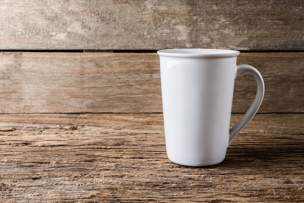 leere weiße Tasse auf hölzernen Hintergrund