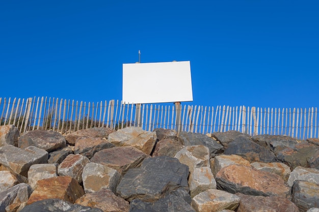 Leere Werbetafel-Attrappe an der felsigen Küste am Strand für Werbung, leere Attrappe