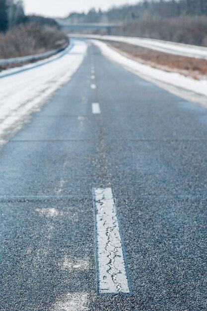 Leere Winterautobahn mit einer gestrichelten weißen Linie am Tag