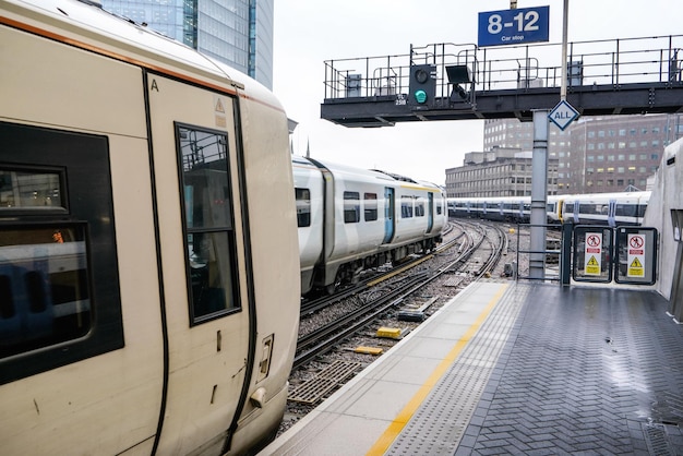 Leerer Bahnsteig am Bahnhof London Bridge, mehrere Züge auf Gleisen, hohe Gebäude im Hintergrund an bewölkten Tagen