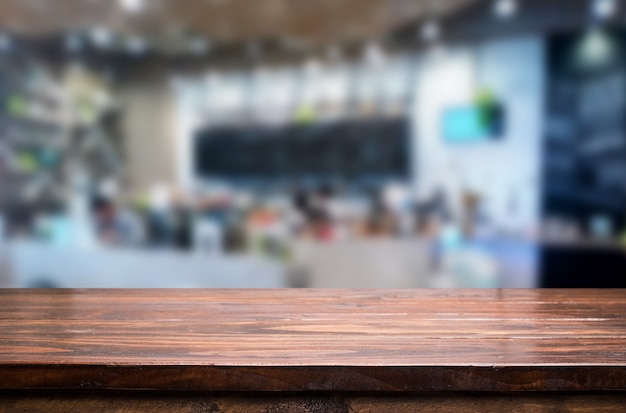 leerer brauner Holztisch und Kaffeestube oder Restaurant verwischen Hintergrund