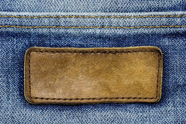 Leerer brauner lederner Aufkleber auf Weinleseblue Jeans