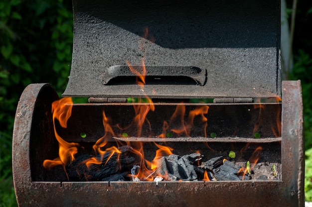 Leerer brennender Holzkohlegrill mit offenem Feuer