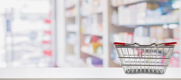 Leerer Einkaufskorb auf Apotheke Drogerie Zähler mit Unschärfe Regale von Medizin und Vitamin ergänzt Hintergrund