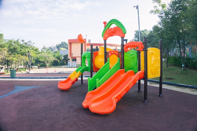 Leerer farbiger Rutschenspielplatz für Kinder in einem Park Landschaftsansicht, die morgens mit niemandem oder keinen Menschen aufgenommen wurde Konzept der Kindheit in der städtischen Nachbarschaft