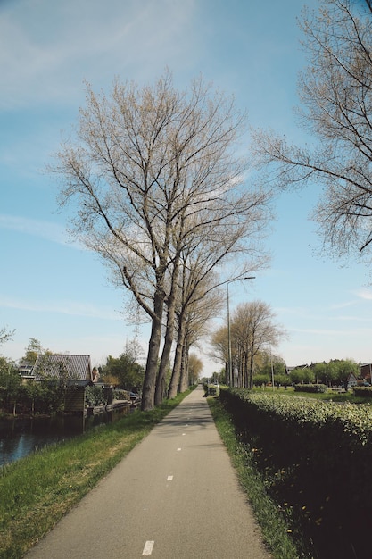 Leerer Fußweg am Feld gegen bewölkten Himmel