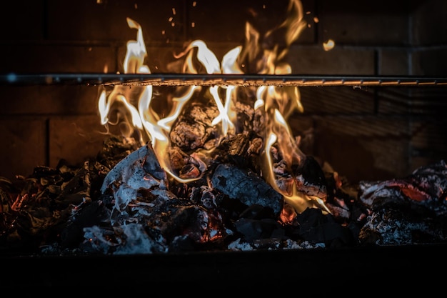 Leerer Holzkohlegrill mit offenem Feuer, bereit für die Fleischplatzierung