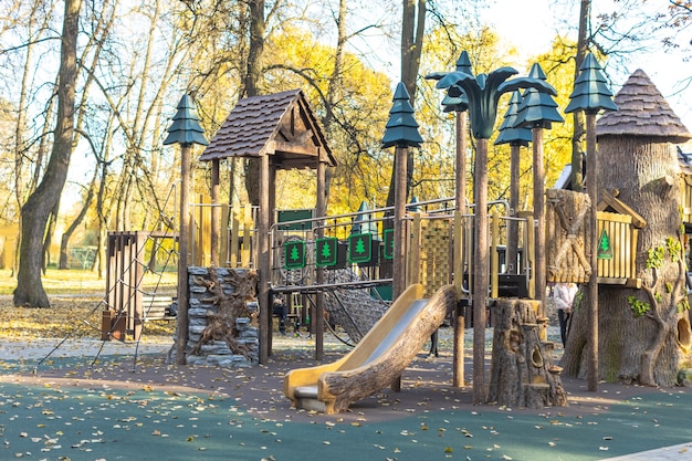 Leerer Holzspielplatz für Kinder im Freien mit Schaukeln im Wald im Herbst draußen mit niemandem