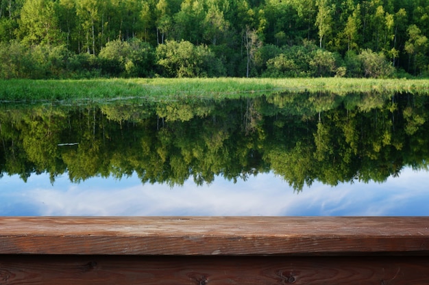 Leerer Holztisch auf dem Hintergrund der Sommerlandschaft