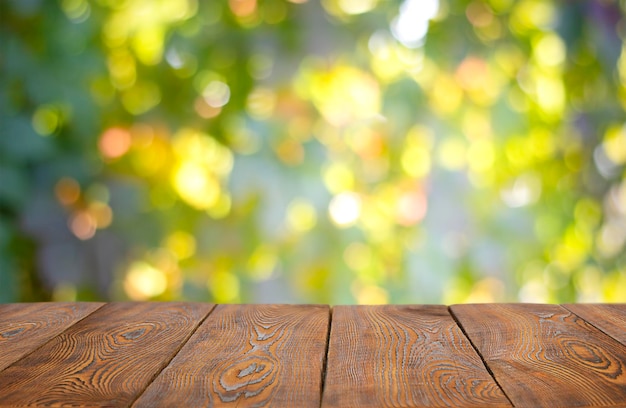 leerer Holztisch auf grünem Gartenhintergrund Bokeh