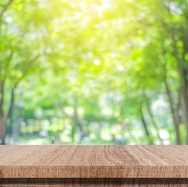 Leerer Holztisch über unscharfen Baum mit Bokeh Hintergrund