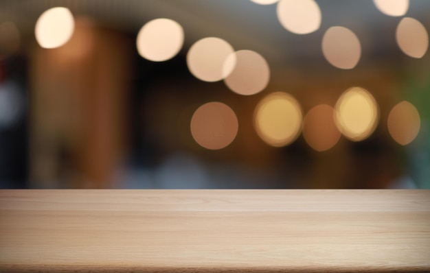 Leerer Holztisch vor abstraktem unscharfem Hintergrund des Cafés kann zur Anzeige verwendet werden