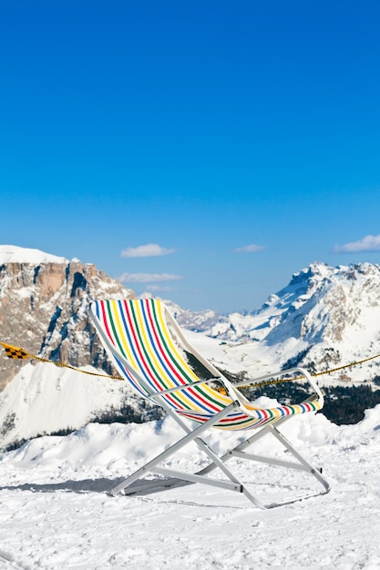 Leerer Klappstuhl auf einem Berg gegen Skigebiet
