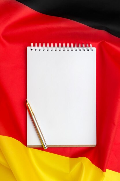 Foto leerer notizblock auf deutscher flagge top-ansicht platz für text