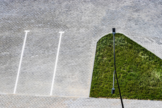 Leerer Parkplatz im Hof eines Hauses mit weißen Markierungen auf Pflastersteinen oder Pflasterplatten. Sicht von oben. Städtische Umgebung.