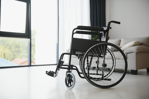 Leerer Rollstuhl im Wohnzimmer Einsames und Gesundheitskonzept