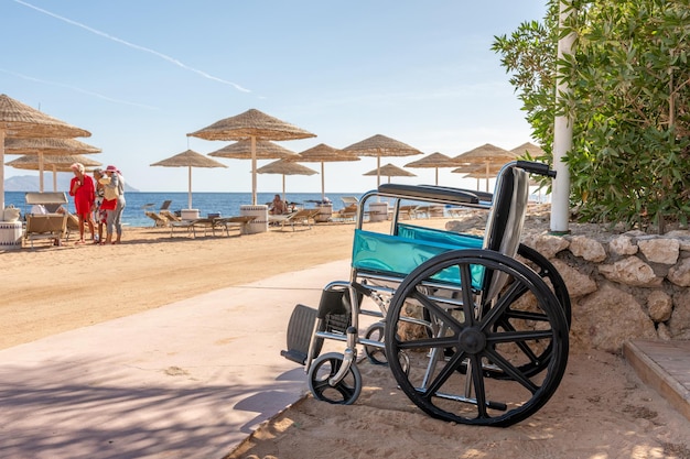 Leerer Rollstuhl vor dem Hintergrund des tropischen Strandes