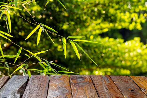 Foto leerer tisch des hölzernen brettes vor bambusgrün lässt hintergrund für anzeige des produktes