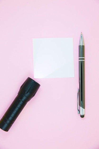 Leerer weißer To-Do-Listenaufkleber mit Taschenlampe und Stift Suche nach Informationen im Internet Nahaufnahme von Notizpapier zur Erinnerung auf rosafarbenem Hintergrund Kopierbereich Minimalismus originell und kreativ