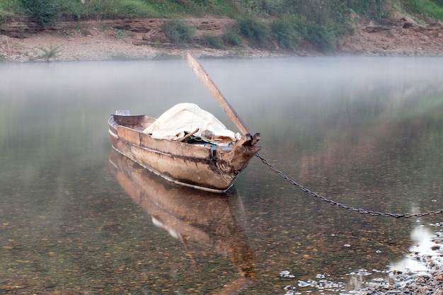 Leeres altes hölzernes Boot auf den Wellen schließen oben