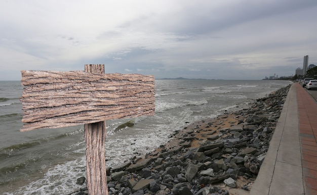 Foto leeres altes holzschild und seehintergrund.