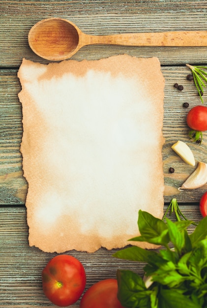 Leeres altes Papier mit Kopienraum für Rezept mit Zutaten und Holzlöffel auf dem Tisch