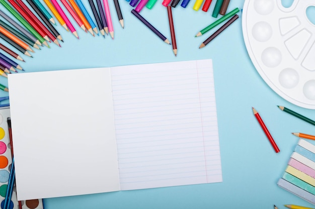 Leeres Blatt aus geraden Linien-Notebooks, Kunst-Schulmaterialien zum Malen auf blauem Hintergrund