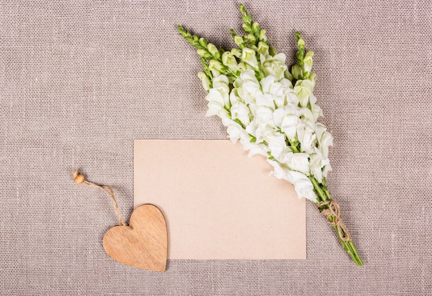 Leeres Blatt Papier und weiße Blumen.