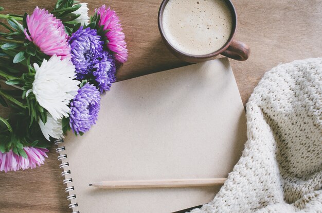 Leeres braunes Notizbuch mit Herbstblumen.