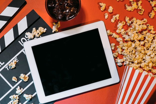 Foto leeres digitales tablet, popcorn, filmstreifen, kino und film-online-streaming-konzept