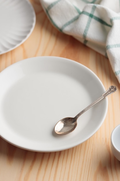 Leeres Geschirr weißer Teller eine Schüssel und eine Tasse auf Holztisch als Hintergrund für ein Gericht foodbackground