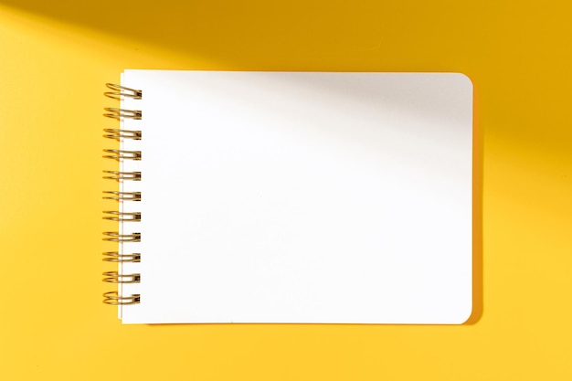 Leeres Notizbuch aus Papier, isoliert auf gelbem Hintergrund. Vorlagenmodell
