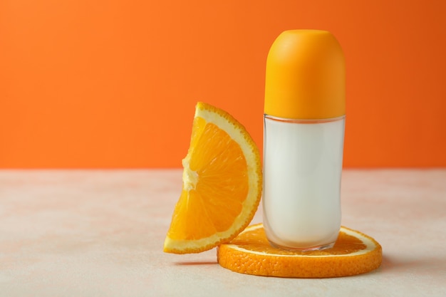 Leeres orange Roll-On-Deodorant vor orangefarbenem Hintergrund