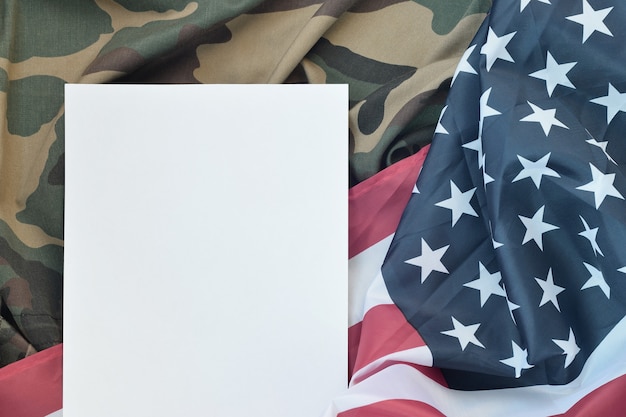 Leeres Papier auf Flagge der Vereinigten Staaten von Amerika und gefaltete Militäruniformjacke