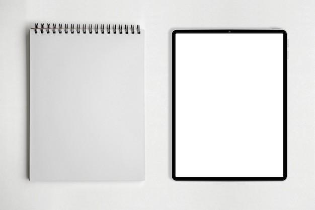 Leeres Papier Notizbuch oder Notizblock und Tablet auf weißem Tisch.