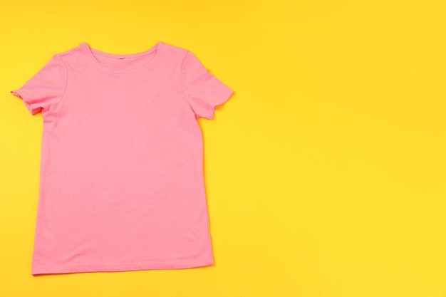 Leeres rosa T-Shirt mit Platz für Druck auf gelbem Hintergrund