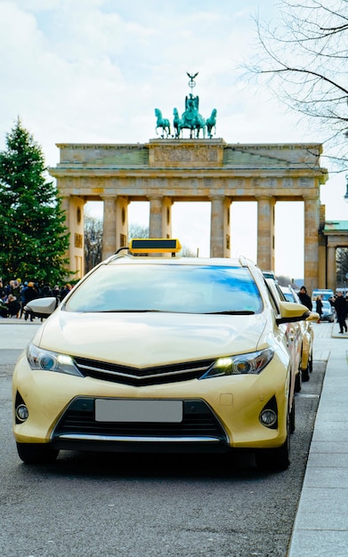 Leeres Taxi-Schild des Autos auf der Straße der Berliner Innenstadt, Deutschland. Brandenburger Tor im Hintergrund. Reisen und Tourismus in der deutschen Hauptstadt. Fahrt im Urlaub oder Urlaub.