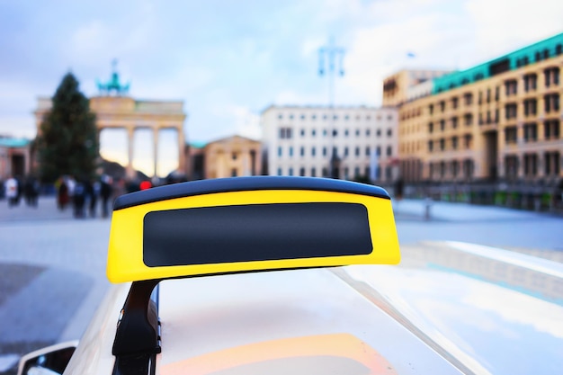 Leeres Taxi-Schild in der Straße von Berlin, Deutschland. Brandenburger Tor im Hintergrund