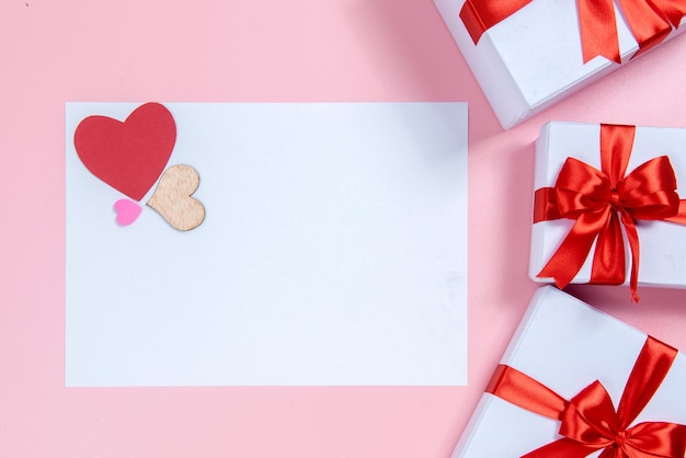 Leeres Weißbuch mit Herzen und Geschenkbox mit farbigem Hintergrund. Valentinstag. Leerer Platz für Kopienraum