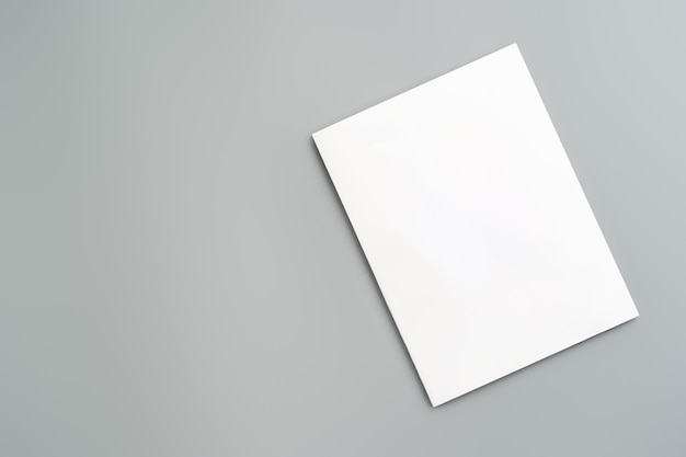Leeres weißes Blatt Papier in einem Winkel auf einer hellgrauen Oberfläche