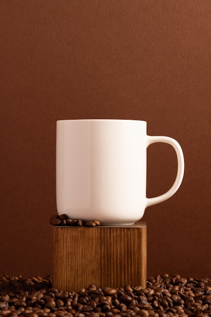 Foto leeres weißes tassenmodell auf braunem hintergrund mit kaffeebohnen