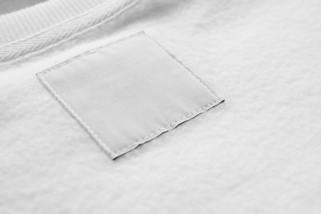 Leerweißes Label für Wäschekleidung auf Stofftextur-Hintergrund