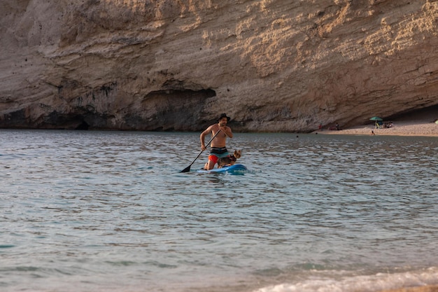 Lefkada Grecia 7 de septiembre de 2021 hombre paddle surf con perro