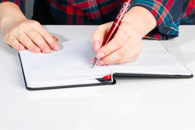 Lefthanders Day Geschäftsfrau schreibt eine Notiz im Notizbuch Mädchen hält einen Stift in ihrer linken Handnahaufnahme